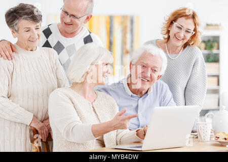 Group of senior friends having video conference with friend Stock Photo