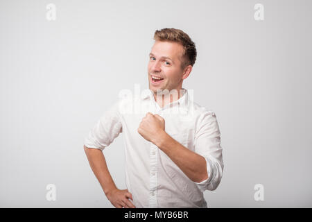 I did it. Young man in white shirt is proud of himself. Stock Photo