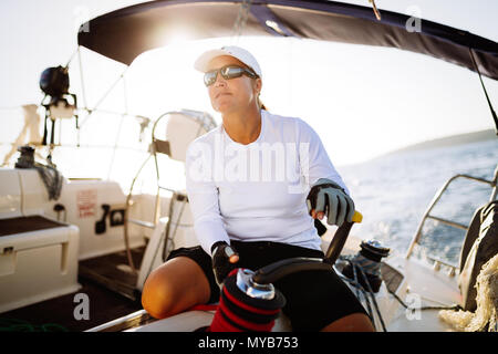 Attractive strong woman sailing with her boat Stock Photo