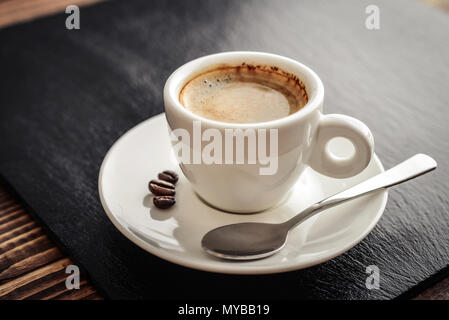 Coffee Espresso. Cup Of Coffee on black slate background closeup. Stock Photo