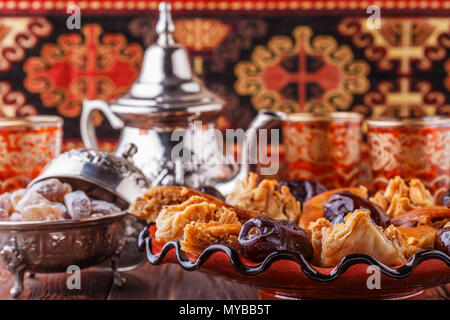 Moroccan mint tea in the traditional glasses with sweets, selective focus. Stock Photo