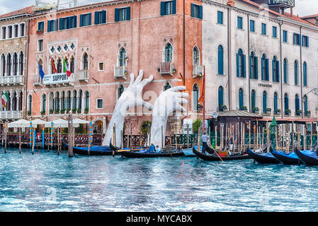 VENICE, ITALY - APRIL 29: The scenic monumental sculpture of a child's hands called 'Support' by Lorenzo Quinn, installed in the Grand Canal of Venice Stock Photo