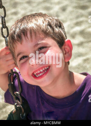 Happy Pre school age 3-5 years old child playing on swing in playground. MR  © Myrleen Pearson.  ........Ferguson Cate Stock Photo
