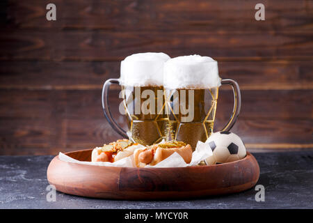 Picture of two mugs of beer and hot dogs on wooden tray Stock Photo