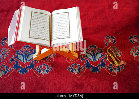 Ankara/Turkey- June 2 2018: Holy Koran on stand and prayer beads on red carpet in Kocatepe Mosque Stock Photo