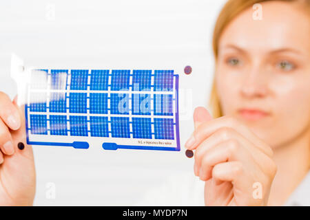 Technician holding a solar cell printed on flexible film. Stock Photo