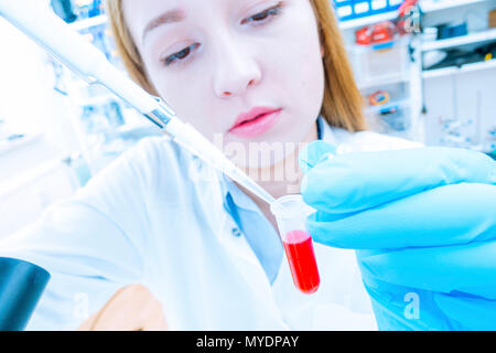 Biological research. Technician pipetting solution. Stock Photo