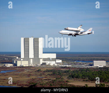 The Space Shuttle Columbia, returning to KSC after the successful STS-32 mission, is poised atop the Shuttle Carrier Aircraft (SCA) as the duo fly by the Vehicle Assembly Building (VAB) at KSC January 26. Stock Photo