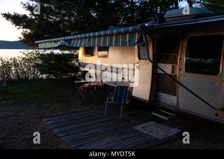 The iconic American made Airstream travel trailer sits in at a campsite at Driftwood Provincial Park in Ontario Canada. Stock Photo