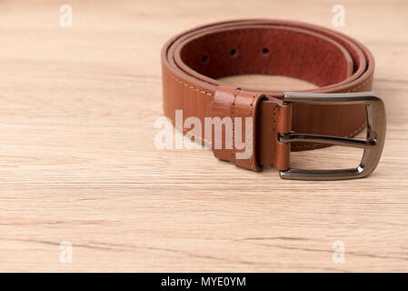 Men's leather belt on wooden table Stock Photo