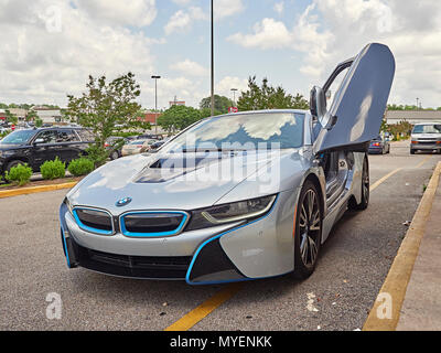 BMW i8 plug in hybrid super car or sports car parked at the curb with driver's door open showing the cockpit of the hybrid electric automobile in USA. Stock Photo