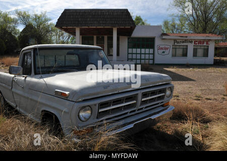 An old Ford pickup truck sits in front of the closed Paradise Cafe and garage in the Route 66 town of Tucumcari, New Mexico. Stock Photo