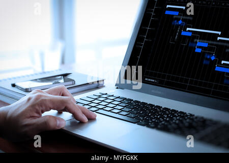 Project manager working and update tasks with milestones progress planning and Gantt chart scheduling diagram.business man working on laptop computer  Stock Photo