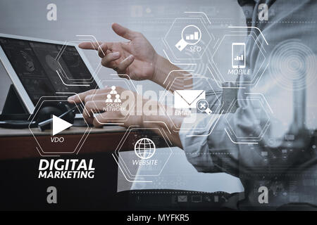 Digital marketing media (website ad, email, social network, SEO, video, mobile app) in virtual screen.business man using VOIP headset with digital tab Stock Photo