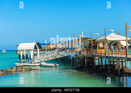 Puerto Ayora, Galapagos, Ecuador - April 1, 2016: People walking and waiting for the boats on the pier in Puerto Ayora in Galapagos on a sunny day. Stock Photo