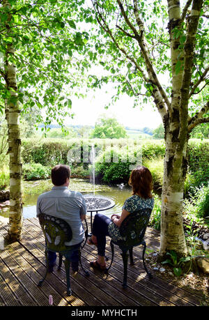 Visitors to the Open Gardens at Newton Valence relaxing at Pond Cottage, Newton Valence, near Alton, Hampshire, UK. 20.05.2018. Stock Photo