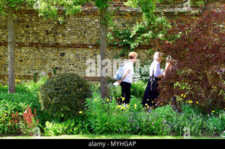 Visitors to the Open Gardens at Newton Valence perusing a walled garden, Newton Valence, near Alton, Hampshire, UK. 20.05.2018. Stock Photo