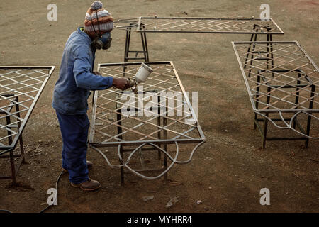 A metal worker in South Africa's Eastern Cape sealing a metal table at a farm workshop Stock Photo