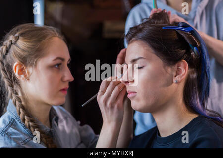 Professional make-up artist and hairdresser working with woman client. Beauty, haircare and make up concept Stock Photo