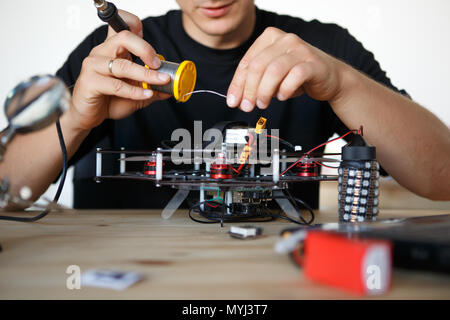 Image of engineer with soldering iron repairing mechanism Stock Photo