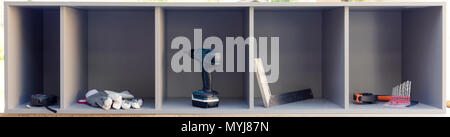 Carpentry tools arranged tidy in the boxes of newly made kitchen cabinet. Furniture making, assembling Stock Photo
