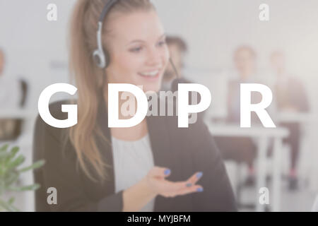 Young consultant working in a contact center calling the customers in connection with the new GDPR law. Blurred photo with a white banner Stock Photo