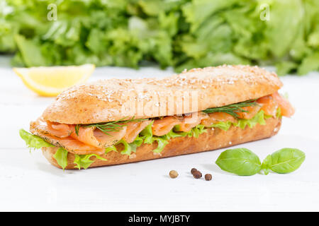 Sub sandwich whole grains baguette with smoked salmon fish on wooden board wood Stock Photo