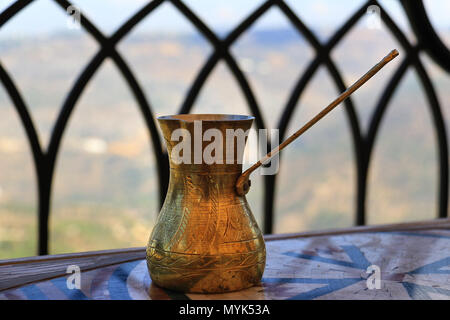 A Lebanese coffee pot made of brass in a traditional setting.