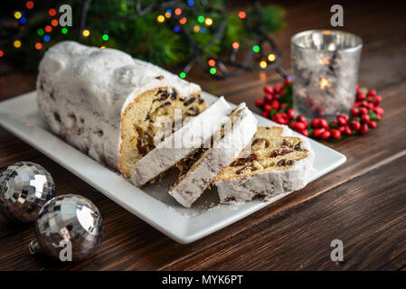 Christmas stollen. Traditional sweet fruit loaf with icing sugar on wooden background Stock Photo