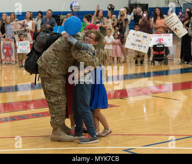 A family embraces during a deployment homecoming May 4, 2017 at Andersen Air Force Base, Guam. Ninetytwo Airmen from the 554th RED HORSE Squadron and two Airmen from the 36th Civil Engineer Squadron, deployed to Southwest Asia September 2016, to provide heavy construction capability in the region. Stock Photo