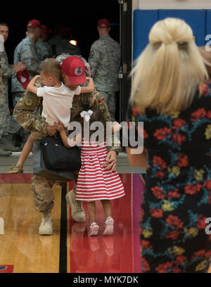 A family embraces during a deployment homecoming May 4, 2017 at Andersen Air Force Base, Guam. Ninetytwo Airmen from the 554th RED HORSE Squadron and two Airmen from the 36th Civil Engineer Squadron, deployed to Southwest Asia September 2016, to provide heavy construction capability in the region. Stock Photo