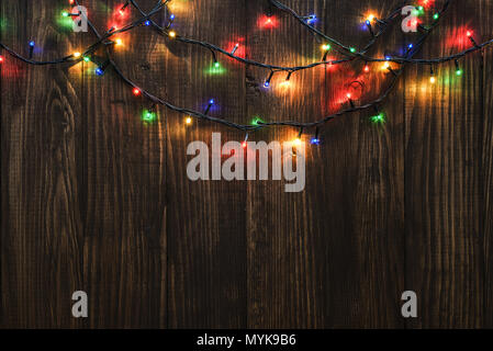 Christmas lights on wooden background. Selective focus Stock Photo