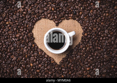 top view heart shape coffee beans on juta textile Stock Photo