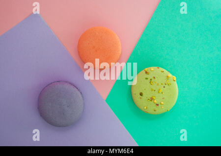 Three delicious french dessert macarons on multicolored background with text space. Stock Photo