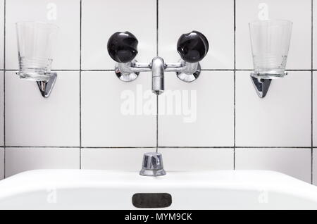 Sink and faucet in a bathroom, black knobs Stock Photo