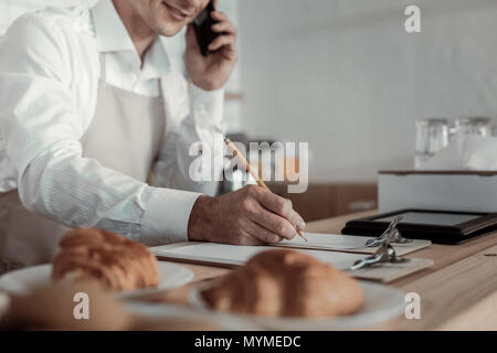 Competent businessman taking order per telephone Stock Photo