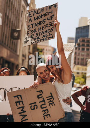 Group of young female activists protesting with signboards on road. Women enjoying during a demonstration on road. Stock Photo