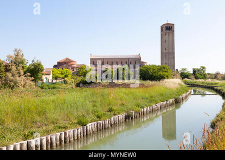 Basilica di Santa Maria Assunta and Church of Santa Foaca at sunrise, Torcello Island, Venice, Veneto, Italy with the belltower reflected in the canal Stock Photo