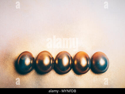 Five golden eggs laying on the floor. Minimal decoration. Easter egg. Stock Photo