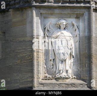 Stone carving (of an angel with a shield) on an outside wall at Magdalen College, university of Oxford, England. Stock Photo