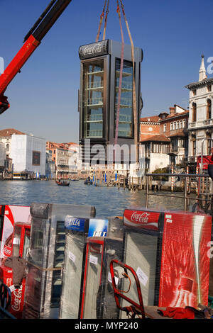 Bizarre sight of Coca cola machines being off-loaded from a barge on the Grand Canal by the Campo de la Carità outside the Accademia, Venice, Italy Stock Photo