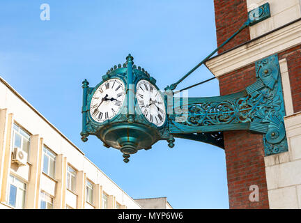 Vintage street clock hanging on a corner of brick building in Samara, Russia Stock Photo