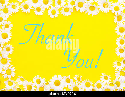 Thank You written on yellow background framed by white daisies Stock Photo