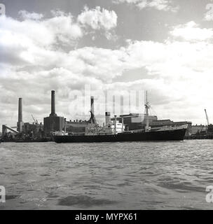 Early 1950s, view from across the river Thames to the south of the river and a working Battersea power station, which at this time, only had three chimneys, London, England, UK. The fourth chimney stack, the south east one, was erected in 1955. Stock Photo