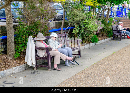 elderly ladies sleeping on a bench Eastbourne promonade Stock Photo