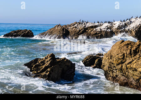 Wave breaking on rocky coastline as it surges towards shore in Leo Carrillo State Park near Malibu, California. Stock Photo