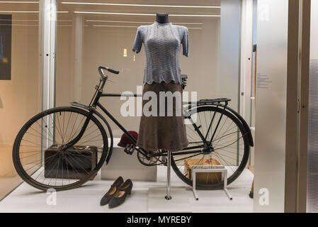 Warsaw Rising Museum, view of a display case exhibiting a typical 1940s Polish woman's blouse, skirt, shoes and bicycle, Poland. Stock Photo