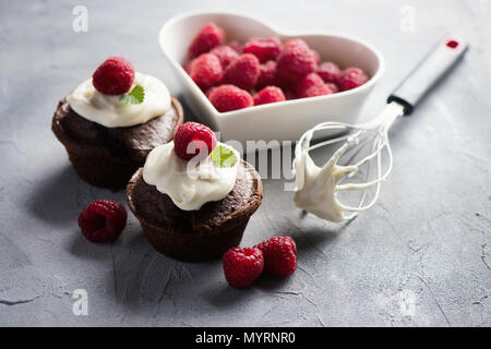 Chocolate muffins or cupcakes with raspberries, healthy breakfast, homemade snack, selective focus, toned image. Stock Photo