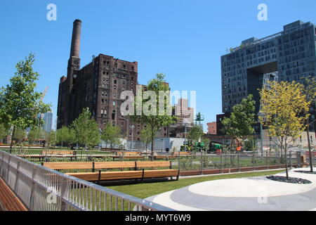 24 May 2018, USA, New York: The building of the former Domino Sugar Factory refinery in the newly built Domino Park beside a new luxury housing complex. A sugar refinery had stood on the 24,000 square metre site since the late 19th century. The site in the Williamsburg neighborhood of the borough of Brooklyn is now being converted into a park with luxury accommodation. Photo: Christina Horsten/dpa Stock Photo