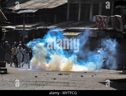 June 8, 2018 - Srinagar, J&K, India - A tear gas shell explodes near the Kashmiri protesters during clashes with Indian government forces after the Friday congregational prayers in Srinagar, Indian administered Kashmir. Thousands of people across the Kashmir valley observed last Friday of Ramadan ( AL-Quds Day) in solidarity with oppressed Palestinians during which rallies, protest demonstrations were taken out while youth clash with government forces after Friday prayers in old city of Srinagar. The protesters were chanting anti-India and pro-freedom slogans. Forces fired tear gas canisters a Stock Photo